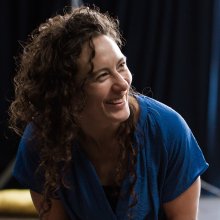 Photograph of smiling woman wearing a blue top.