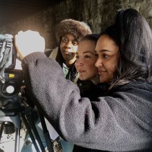 Image of three young filmmakers using camera equipment