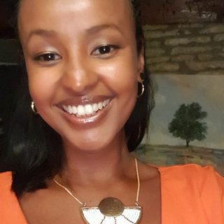 A photo of Fozia Ismail's head and shoulders wearing a bright orange dress