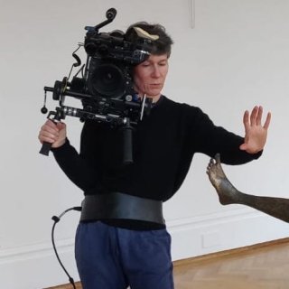A person holds a large camera.