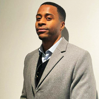 Image of Vincent Baidoo a Black male, creative technologist in a grey suit.