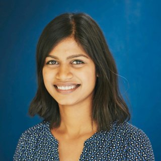 Head shot of a smiling woman on a blue background.