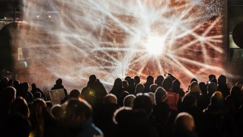 Crowds of people watching a light show.