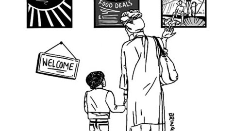 Adult and child stand looking at posters and a welcome sign