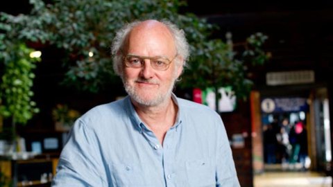 Photo of Dick Penny. He is a man with glasses, white hair and a blue shirt standing in Watershed's café