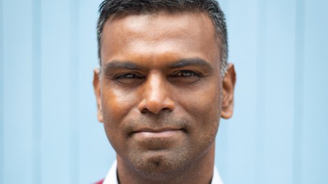 Head shot of man wearing shirt and red jumper