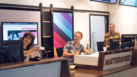 Three Watershed team members smiling into the camera at Box Office