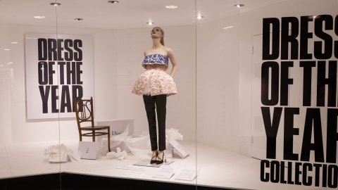 Photo of a fashion model in a shop window advertising Dress Of The Year Collection