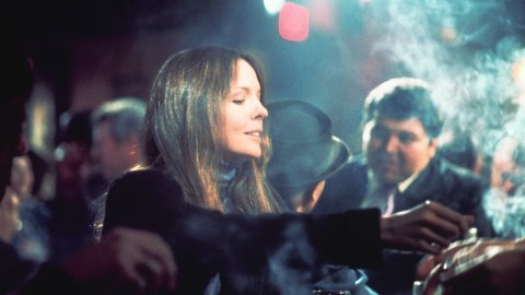 A woman sits alone at a smoky bar.