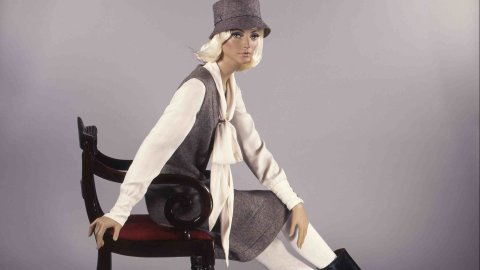 Photo of a fashion model sitting on a chair looking into the camera