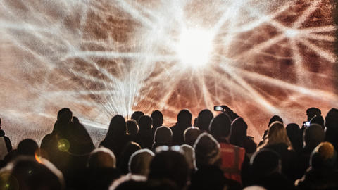 A crowd watches projections on water