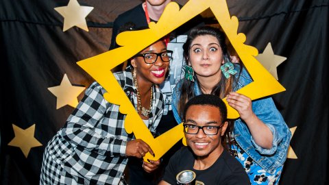 Photo of four young people, dressed up and celebrating