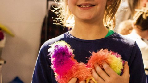Anonymous photo of a child cuddling a colourful toy