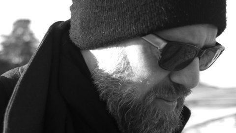 Duncan Speakman is a white man wearing a black beanie and black sunglasses, he is turned to the side.