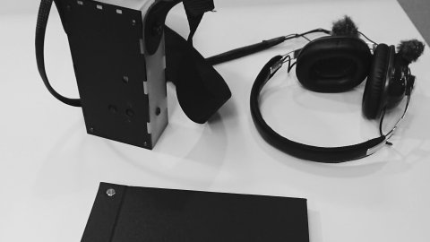 A selection of materials used for the Only Expansion exhibition including a sound device, notebook, and headphones. 