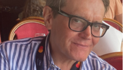 Stephen Woolley wears glasses, has greyish hair and wears a stripy shirt