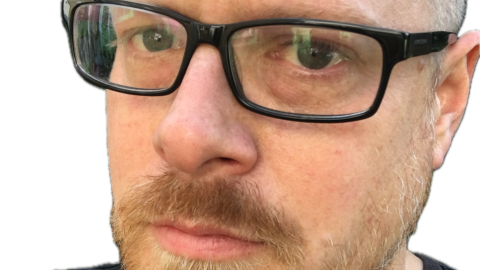 Photo of James White. A white man wearing black rimmed glasses and a short beard and hair.
