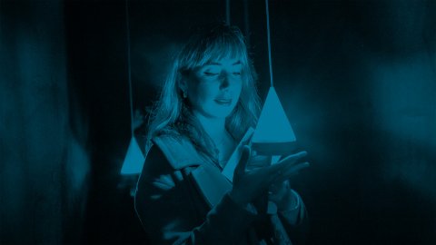 Photo of a woman holding a glowing, suspended digital device