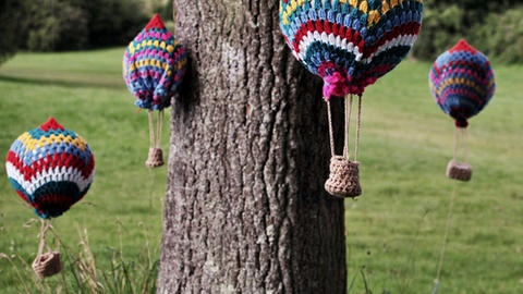 Mini wool balloons hanging from a tree