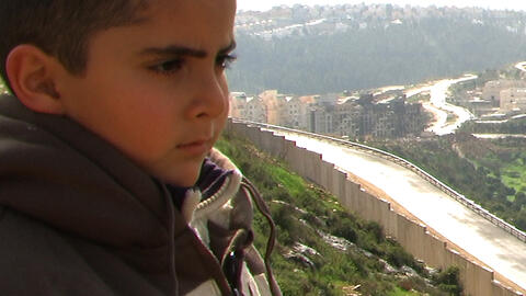 A boy looks over the wall