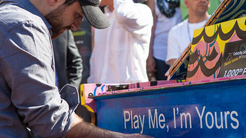 Man playing a piano outside