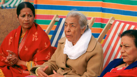 Three women sitting on deckchairs on the beach