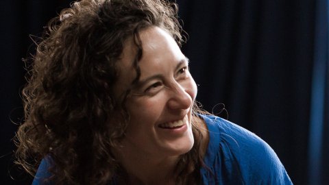 Photograph of smiling woman wearing a blue top.