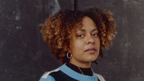 Photo of a black woman wearing a blue, black and white jumper