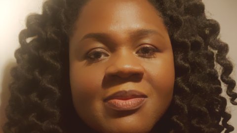 Head shot of a smiling woman wearing a red dress