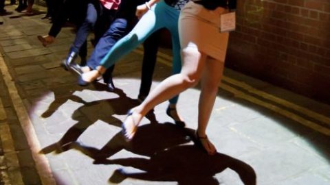 Girls dancing under a street lamp