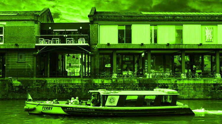 A photo of the exterior of Watershed, a long, low ex-warehouse building overlaid with a green tint