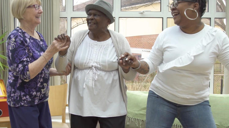 Three women dancing and smiling