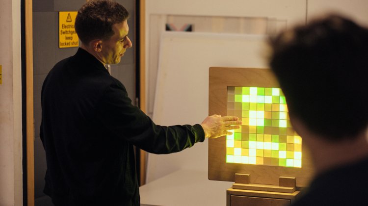 A person interacts with an unusual device with sensory lighting