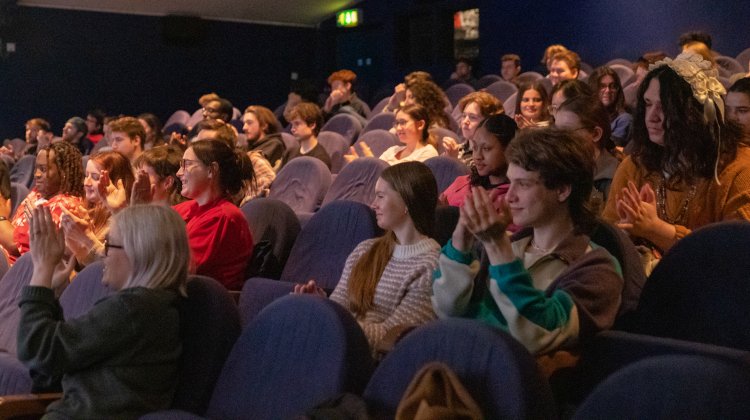 A crowd of people sit in an auditorium