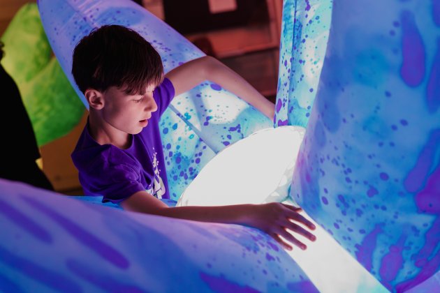 A child hugging a robotic inflatable