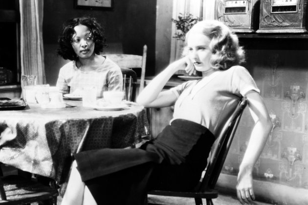 Black and white photo from the thirties of two women sat at a table