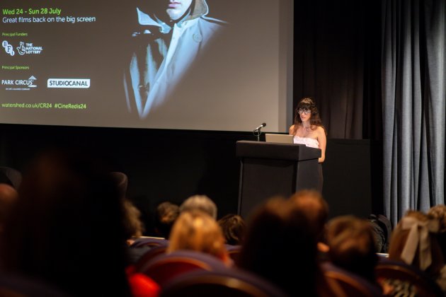 Christina Newland delivering her keynote speech in front of an audience at Cinema Rediscovered 2024