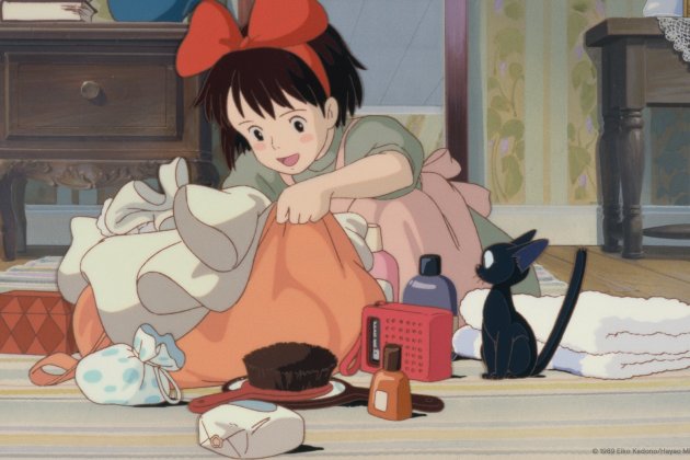 Animated girl with a red bow unpacking a bag on the floor, surrounded by toiletries and a small black cat sitting next to folded towels.