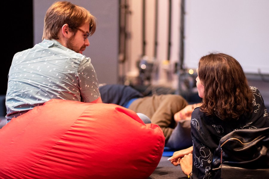 Photo of three people talking at Watershed, one on a bean bag, and two lying down