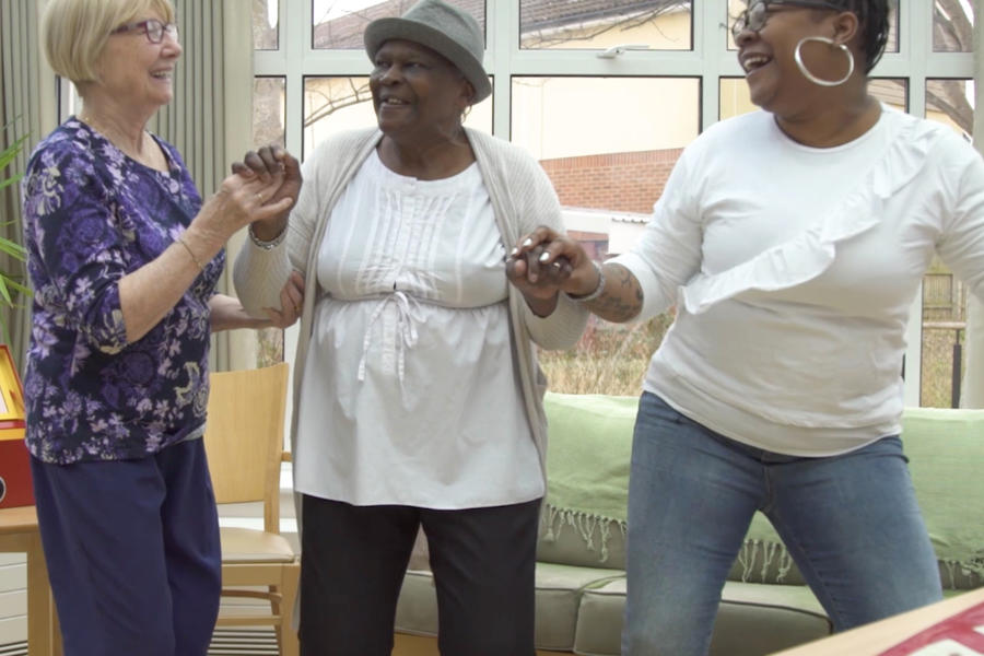 Three women dancing and smiling