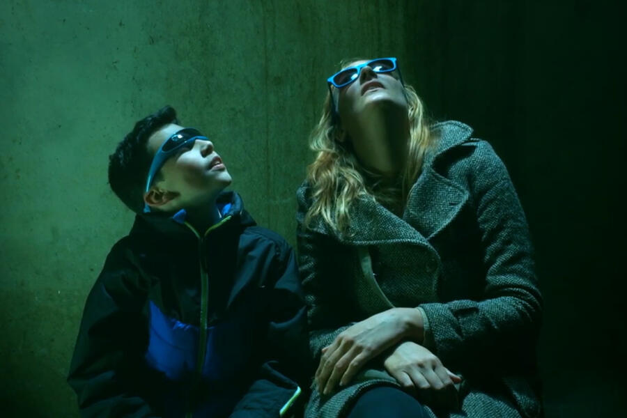 Two people wearing sunglasses looking up