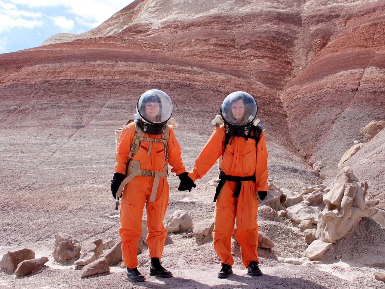 Artists Ella Good and Nikki Kent in orange space suits, from Building a Martian House