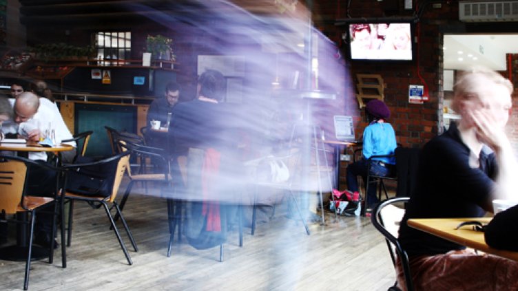 People moving through Watershed Café/Bar People sitting in a cafe.