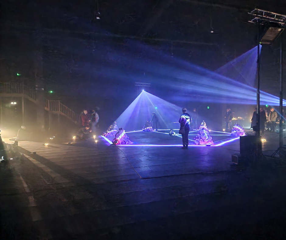 Pyramid shaped light installation, people looking at it