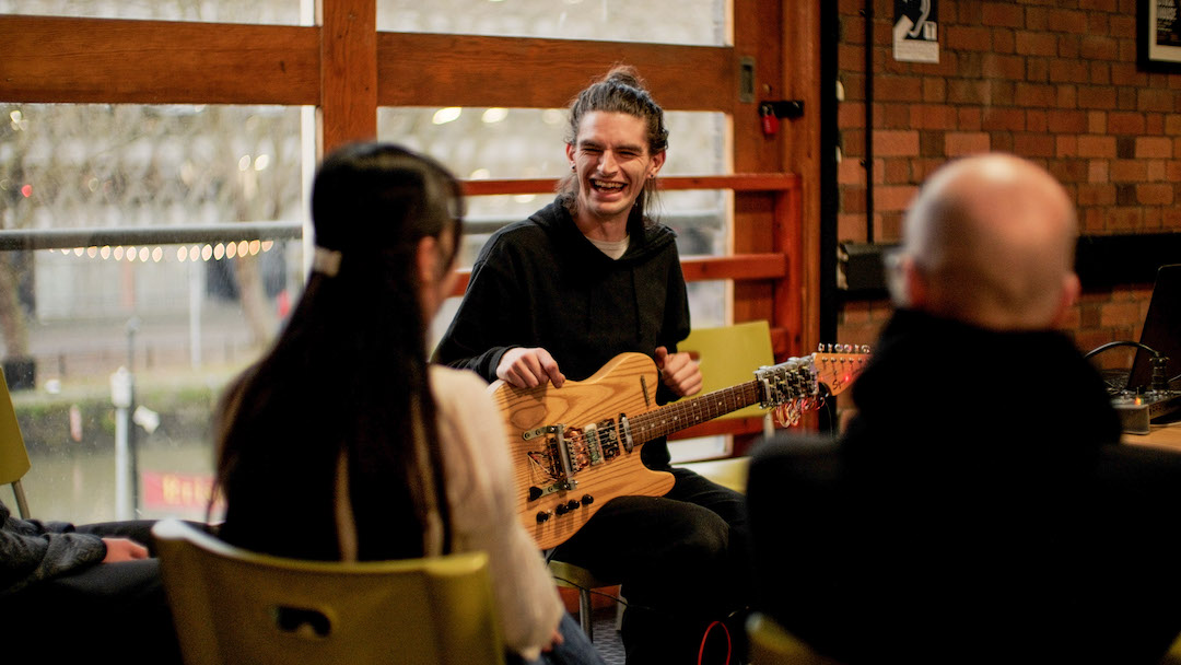 Image of group discussing the semi-automated guitar