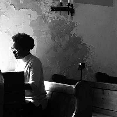 A portrait of Marie in black and white sitting at a table