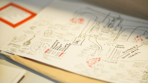 A close-up of a detailed sketchbook page filled with diagrams, notes, and doodles related to sound design and conductive materials.