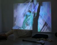 Image of a figure in front of a projection, wearing MiMu Gloves