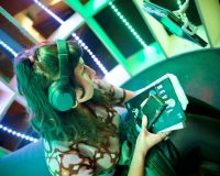 A person sits inside the colourful Joey Pod, wearing headphones and holding their phone