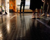 People shown from the knee down standing on the floor of the Pervasive Media Studio, Bristol.